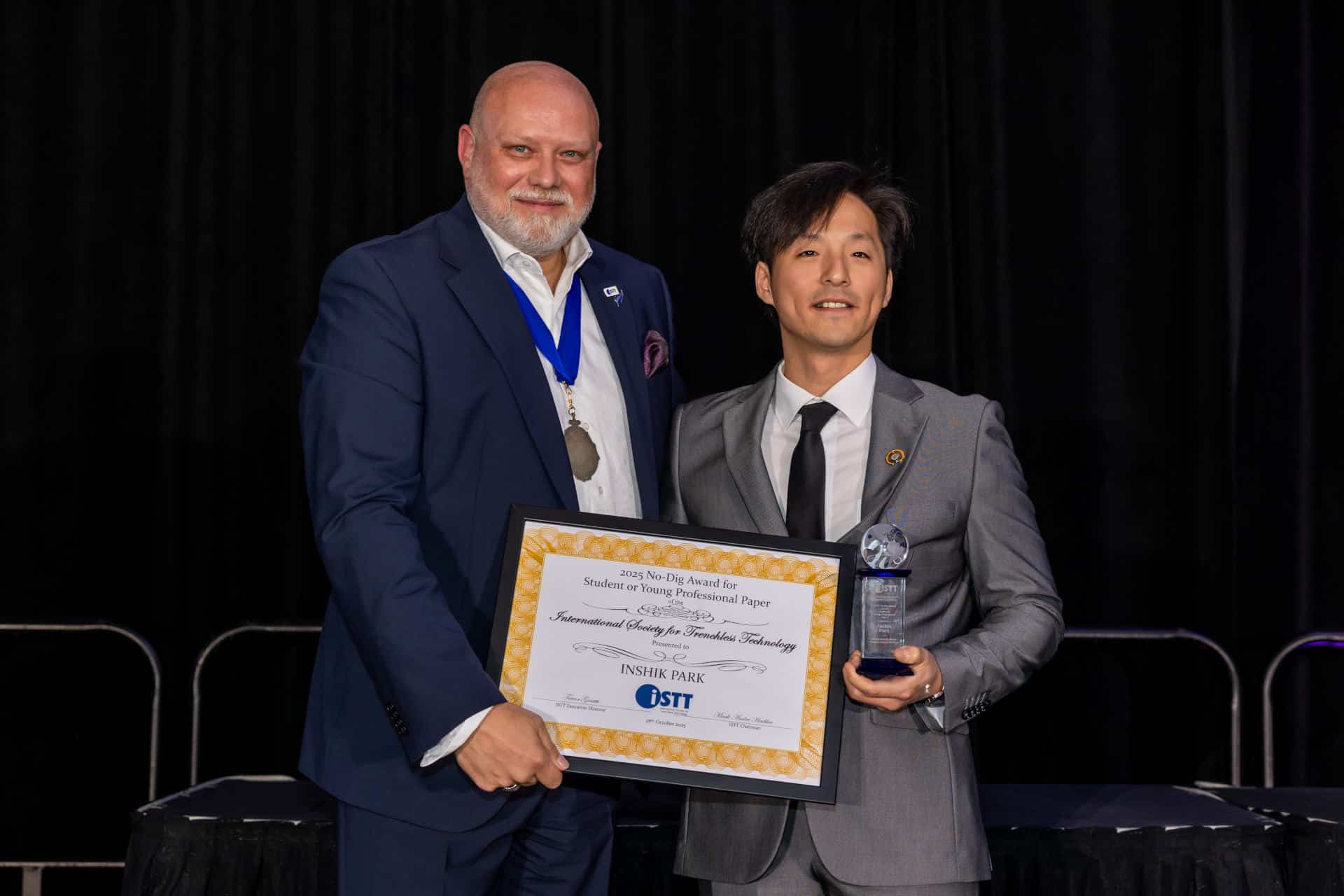 Mark André Haebler, ISTT Chairman, presents Inshik “Justin” Park, from the University of Alberta, with the Student Paper Award
